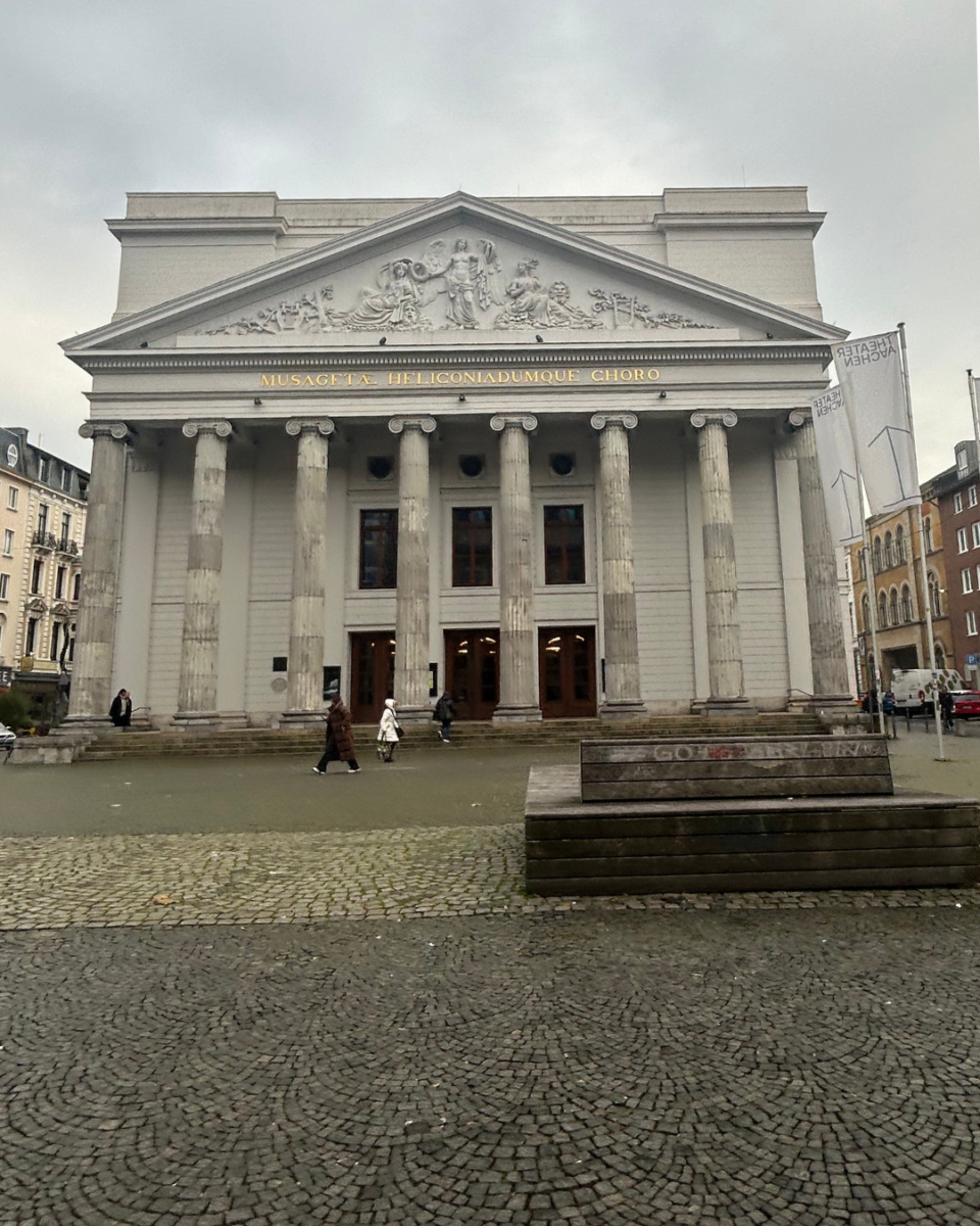 Neoclassical facade of the Theater Aachen with large columns and a central pediment in the city square.