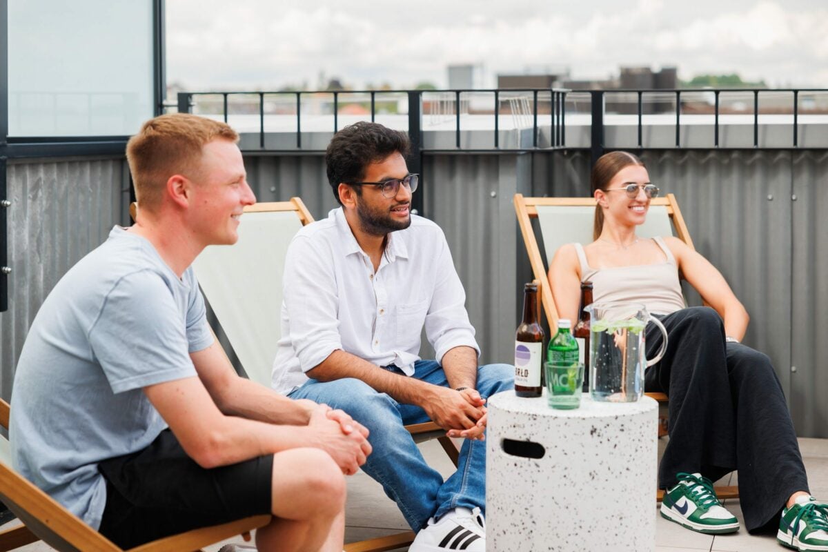 Menschen, die sich an einem sonnigen Tag auf einer Dachterrasse treffen