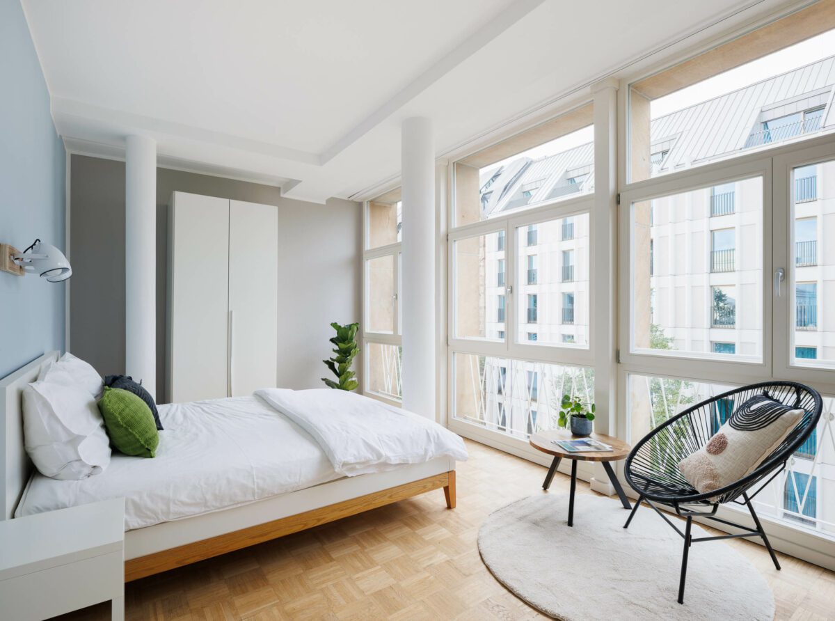sauberes und helles Hotelzimmer mit großem, bequemen Bett und großen Fenstern